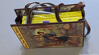 Top view of book-cover handbag filled with two yellow Nancy Drew books