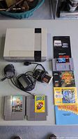 Full lot overview showing NES console, cartridges, controller, cables, manuals