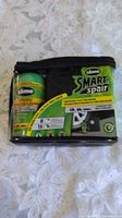 Front view of sealed Slime Smart Spair kit showing sealant bottle and inflator inside clear pouch