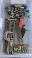 Bin with micrometer, sine bar, reamers, gauges, stones