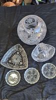 all six clear cut-crystal pieces displayed on dark cloth