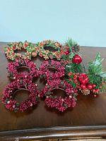 All nine napkin rings and faux greenery pick displayed on tabletop