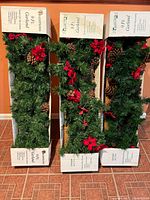 Three boxed 9-ft garlands standing side by side