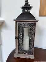 Front view of ornate rectangular lantern with candle