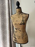 Full view of mannequin torso with Paris print and finial top