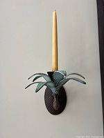 Full view of pineapple sconce mounted on wall with candle