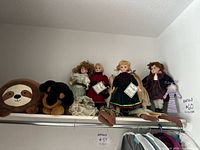 Shelf view showing four porcelain dolls and two plush toys