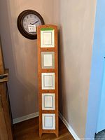 Front view of wooden floor easel picture stand beside wall clock