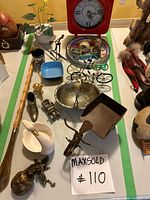 Overall lot view showing clock, wire bicycles, bowl, shoe horn and multiple small items
