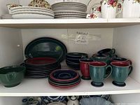 Cabinet shelf with full Denby set including plates, bowls, mugs, platter visible