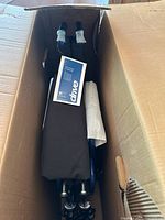 View inside box showing folded wheelchair and manual