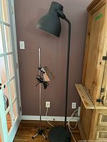 IKEA grey floor lamp beside Intertek chrome spotlight lamp