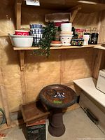 Lot overview showing bird bath, box of solar lights, copper planter, assorted planters on shelf