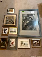 group shot of nine framed artworks laid on carpet