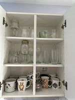 Full cabinet view showing mugs, glassware, and teapot