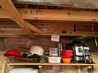 Shelf with Instant Pot, Air Fryer Lid box, colander, bowls, breadmaker visible