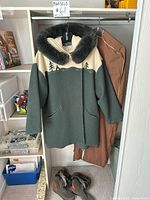 Full view of LaParka coat hanging with boots on floor