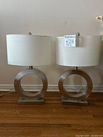 Front view of both stainless ring-base lamps with shades