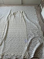 Quilt laid out with crochet coverlet on top showing scale and patterns