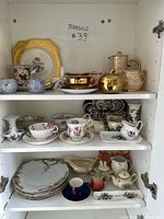 Full cabinet view showing all china pieces on three shelves