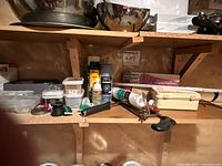 Shelf with assorted tools, axe handle, caulking gun, paint cans, fastener boxes