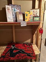 Shelf view with hooked rug and assorted wall decor items