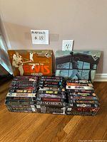 Stack of WWF VHS tapes in front of two vinyl albums