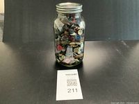 Full view of jar filled with assorted buttons