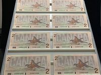Eight of the ten sequential $2 banknotes in storage page