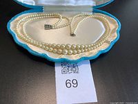 Full view of necklace in case showing double strands and clasps