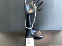 Necklace draped on display hand