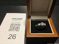 Ring in presentation box beside lot card