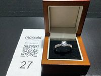 Ring in display box beside MaxSold card