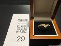 Front view of gold-tone chevron ring with clear stones in display box