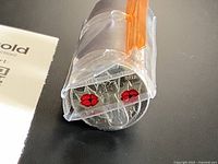 Roll of coins in clear tube, two end coins show red poppy design