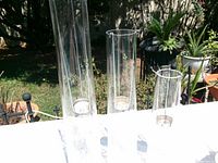 four clear cylindrical vases on table