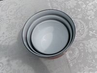 Three nested red enamel bowls sitting together