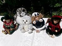 Group view of three dolls and two plush owls on table