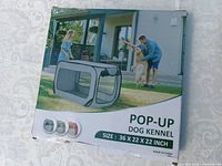 Front of boxed pop-up dog kennel showing product image and size