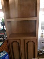 Full view of bookshelf showing open shelves and cabinet doors