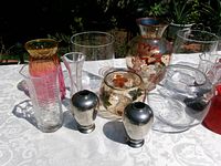 Left side close-up showing ribbed vase, bud vase, silver vases, and leaf-motif vessels