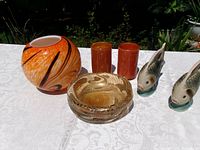 Complete lot on table: orange globe vase, gold fleck bowl, two orange cylindrical vases, pair ceramic fish