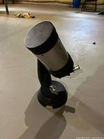 Full view of telescope on base showing silver optical tube and black mount