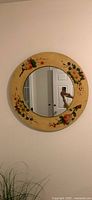 Full view of round floral mirror hanging on wall
