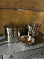Two stockpots with lids and one mixing bowl