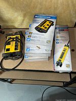 Stack of three boxed 8-outlet power bars, one boxed 6-outlet power bar and one loose 8-outlet power bar