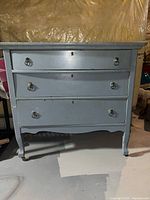 Front view of light blue three-drawer chest showing full piece and hardware