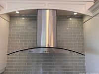Front view of stainless steel and glass range hood installed
