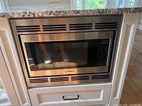 Front view of Bosch stainless built-in microwave installed in cabinetry