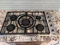 Top view of entire cooktop showing grates, burners, knobs